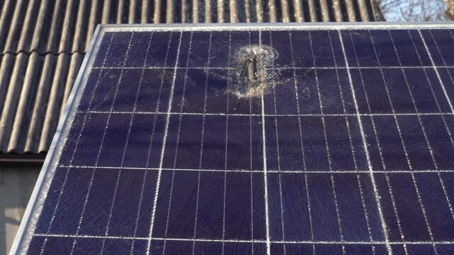 Solar panel with hole and crack on a bright sunny day. 