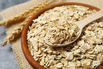 Composition with oatmeal flakes on gray background. Cooking breakfast