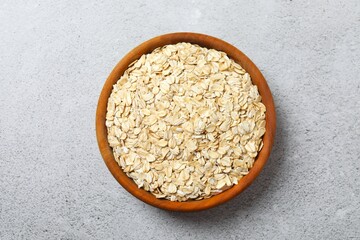 Composition with oatmeal flakes on gray background. Cooking breakfast