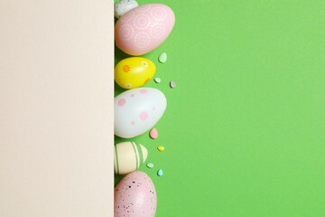 Happy Easter. Colorful eggs with paper card on color background, space for text or advertising