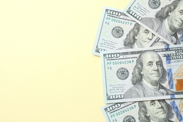 Money, one hundred US dollar bills on a beige texture. Money is scattered on the table. Finance and economics concepts. Saving money concept