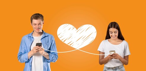 A young couple enjoys sharing affectionate messages on their smartphones, celebrating St....