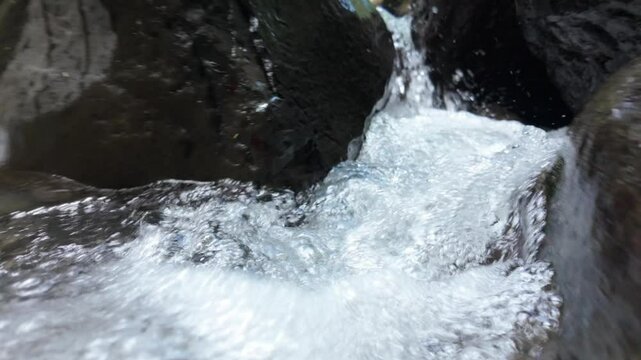 Crystal clear river water flowing over rocks in slow motion (Location: El Salto, La Fortuna, Costa Rica)