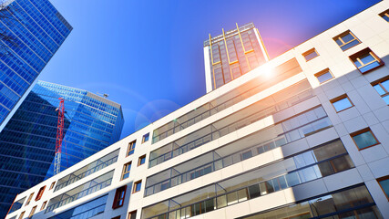 View of an modern apartment building standing next to a new modern office building with a glass facade.
