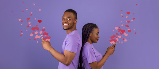 A couple stands back to back, each holding a smartphone. They joyfully exchange affectionate messages filled with heart emojis, celebrating their love on St. Valentine's Day.