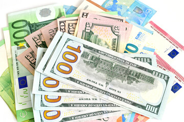 European and American paper money of various denominations lie on a white background.