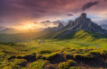 Lush green valley, beautiful alpine mountains during colorful sunset in summer. Passo Giau,...