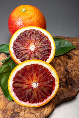 Sicilian sweet juicy yellow and red blood oranges with green leaves close-up
