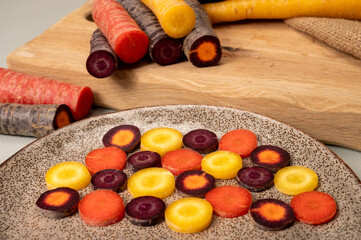 Colorful fresh raw purple, yellow, red and purple-orange carrots roots vegetables from greenhouse in the Netherlands