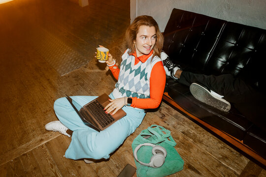 High angle view of businesswoman talking with colleague while sitting on floor