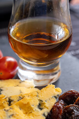Whiskey and cheese pairing, tasting whisky glasses and plate with sliced crumbly old blue stilton and blue shropshire cheeses, Great Britain food and drink