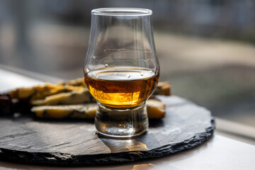 Whiskey and cheese pairing, tasting whisky glass and plate with sliced blue stilton and blue shropshire cheeses, Great Britain food and drink