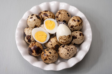 Fresh small spotted partridge or quail bird eggs uncooked and cooked