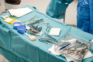 A surgeon organizing medical tools and preparing for surgery in a hospital operating room.