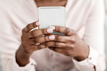 Useful App. Closeup of unrecognizable black woman using smartphone at home, cropped image with free space