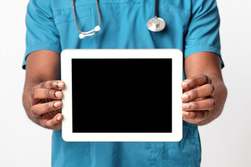 Empty digital tablet screen in african man doctor hands, close up, white background, panorama