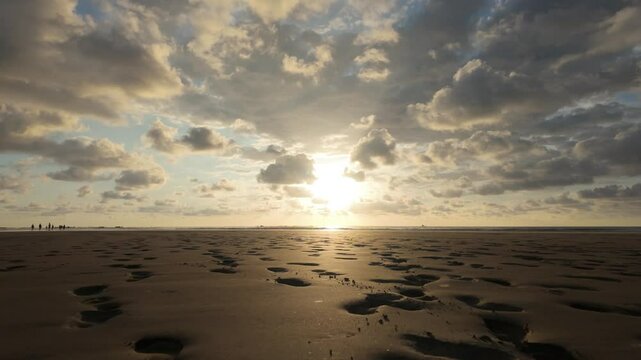 A slow tracking forward shot over footprints on the beach at sunset. Location: Uvita, Costa Rica