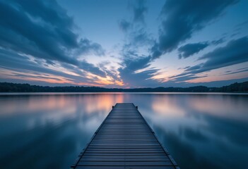 Naklejka premium Serene Dusk Lakeside View. Wooden Dock Leading To Calm Waters. Vibrant Sunset Reflections In Nature. Soft Orange And Blue Sky. Wispy Clouds Create Visual Interest. A Peaceful Twilight Scene.