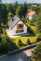 Modern house surrounded by lush greenery in a peaceful neighborhood, showcasing contemporary architecture and well-maintained landscape under a clear blue sky