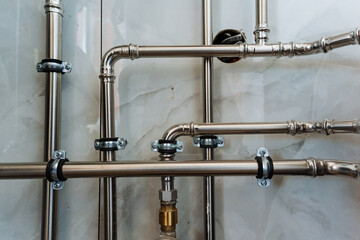 Sleek stainless steel pipes against a resilient wall create a stunning visual display with their...