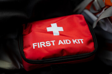 A bright red first aid kit adorned with a prominent white cross, signifying its purpose for medical assistance and emergency care, is an essential item for health and safety