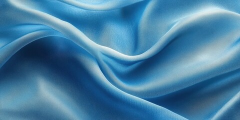 Obraz premium Soft blue fabric drapes elegantly in gentle waves, showcasing its smooth texture and vibrant color under ambient light