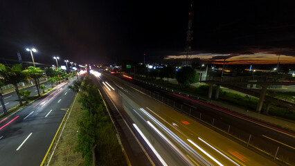 Marilia, Sao Paulo, Brazil, February 19. 2025. traffic on the Highway and silhouette of a telecommunications antenna in Marilia city, during a sunset