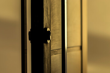 Modern wooden door with metal handle and lock during magic dawn, in a house in Brazil