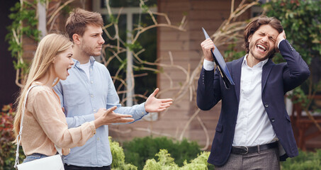 Annoyed clients arguing with irritated real estate agent about property purchase, outside