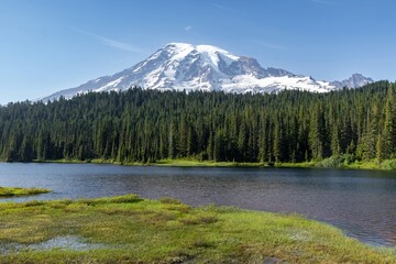 Stunning view of Mount Rainier, reflecting on a serene alpine lake. Tranquil wilderness scene. ...