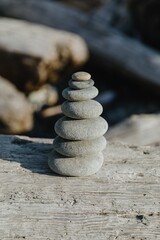 A stack of smooth grey stones balanced on driftwood. Nature's art, perfect equilibrium. Ruby Beach, Forks, Washington, USA
