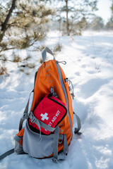 A backpack with a first aid kit in the snow