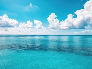 Fototapeta premium Serene Blue Ocean with Soft White Clouds under a Clear Sky, Reflecting Light and Creating a Peaceful Seascape in Bright Daylight