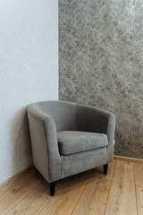 In a cozy corner of the room, a lovely grey chair elegantly sits beside the wall, significantly...