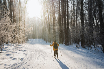 A person is skiing down a snowy path in the woods