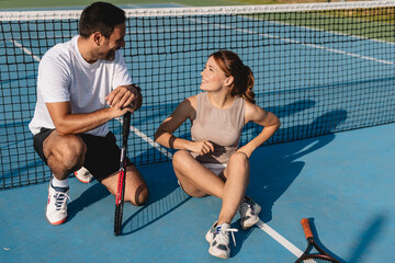 Young couple playing tennis outdoors enjoying a fun summer game