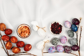 Easter celebration concept. Recipe for dyeing Easter eggs with natural dyes, ideas for homemade Easter cooking. Marbled eggs dyed with hibiscus tea and onion peel, Light elegant background.