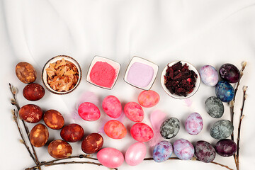 Recipe for dyeing Easter eggs with natural dyes, ideas for homemade Easter cooking. Marbled eggs dyed with hibiscus tea, onion peel and pink matcha tea, Easter celebration concept.