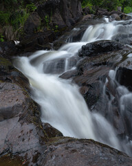Long exposure of a river flowing along a rocky path. 