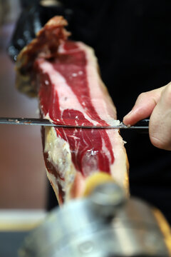 experto de corte de jam&oacute;n cortando loncha de jam&oacute;n ib&eacute;rico con cuchillo profesional