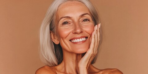 Mature woman with silver hair smiling, displaying a warm and friendly demeanor. A close-up portrait taken under soft natural lighting.