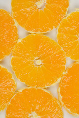 A close-up, top-down shot of several orange slices arranged in a pattern, highlighting their vibrant color and texture