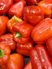Vibrant red bell peppers are abundant in a market basket, showcasing their freshness and vivid color. Close-up