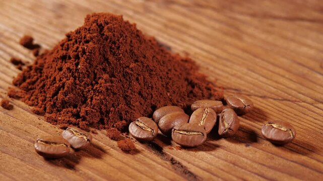 Arabica Coffee Beans Maragogipe on a Wooden Background with Rotating Effect. Elephant Beans with Ground Coffee