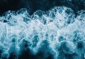 Obraz premium Turbulent Ocean Waves Displaying Beautiful Patterns with Bright Foamy Crests Underneath the Clear Blue Sky Captured from Above