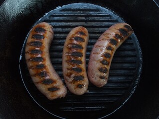 For a delightful meal, sauté some juicy pork sausages in a charming cast iron skillet for an irresistible flavour. Enjoy the beautiful top view of your creation!