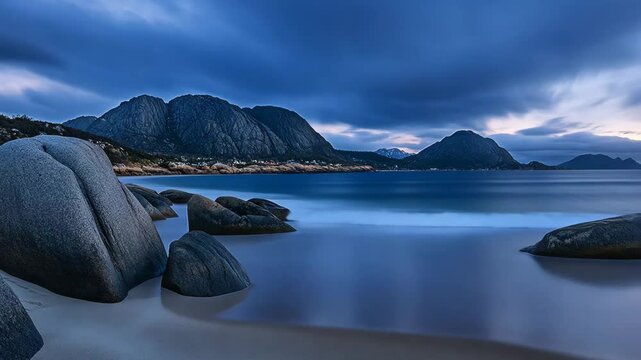 Serene coastal landscape at dusk with rocky shores and distant mountains in soft twilight hues