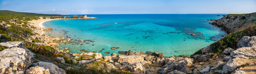 Coastline with a sandy beach and rocky shores near the northeasternmost cape of Northern Cyprus. Crystal-clear waters of a blue lagoon and the untouched beauty of the Mediterranean