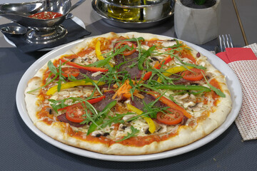 Delicious gourmet pizza topped with colorful vegetables savory meat and fresh arugula a culinary delight for the senses!