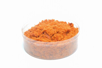 Close up Dark brown beef floss in a plastic bowl isolated on white background.Food industry concept.Copy space for text.For graphic design,3D rendering or banner background